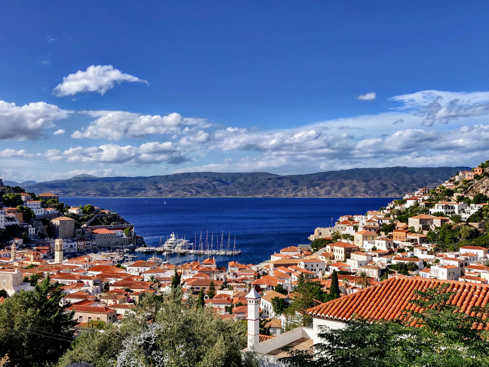 Hydra harbour and town seen from above with the Peloponnese coast beyond